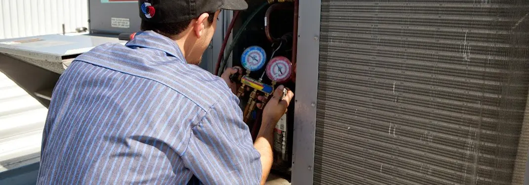 HVAC technician servicing a condenser unit in Rocky Mount