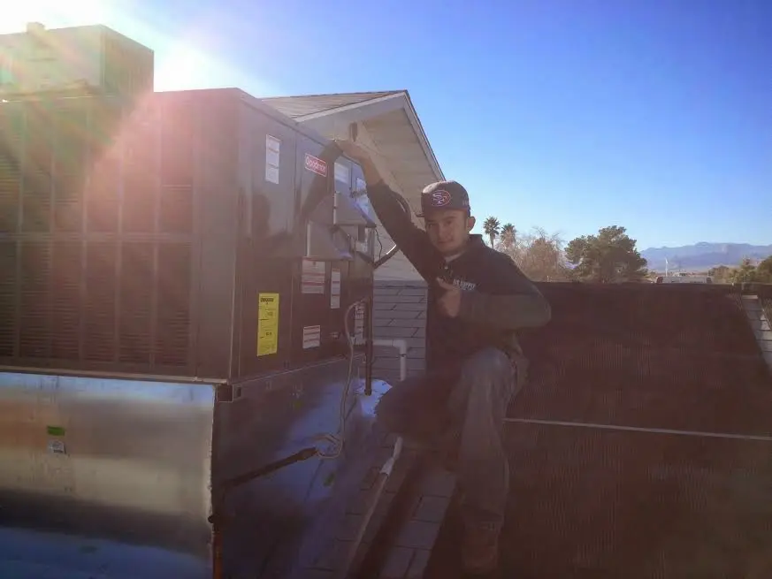 HVAC technician performing Heat Pump Repair on a rooftop unit in Rocky Mount